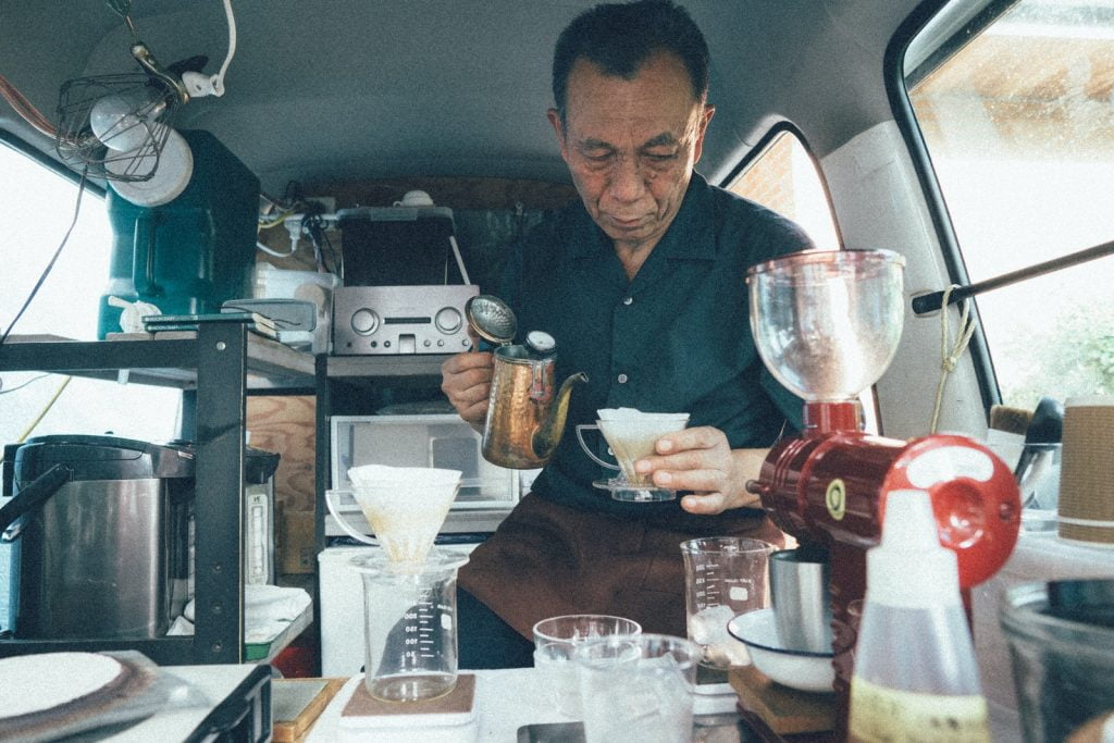 man in vehicle serving coffee